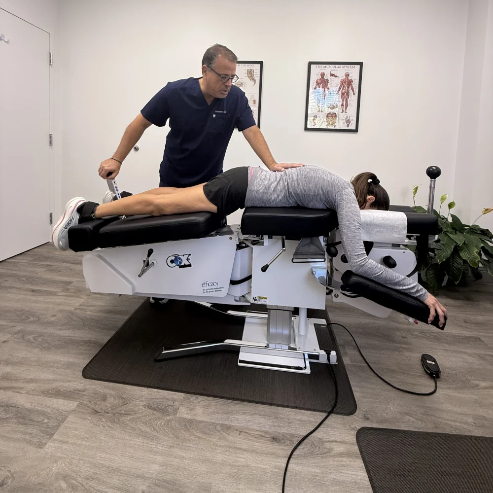 Dr. Kleinfeld administering spinal decompression therapy to a runner using the Cox Technic table at his Jupiter chiropractic clinic.
