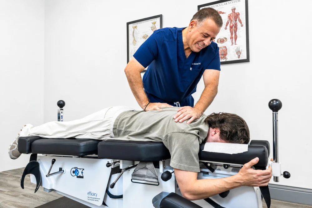 A clinical treatment session featuring flexion-distraction spinal decompression, representing modern care available at the Jupiter office of Dr. Kleinfeld.